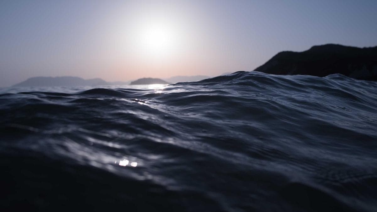 Two scientists in PPE conducting an experiment with a microscope and lab equipment.